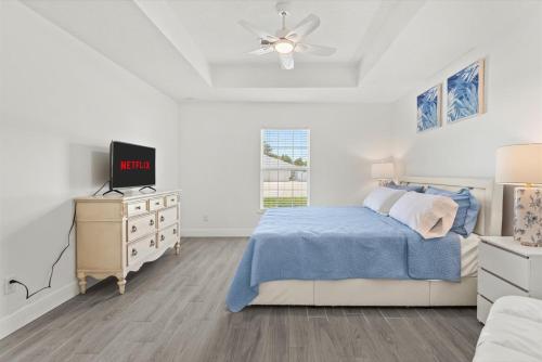 a bedroom with a bed and a dresser with a tv at Coosa Dr in Port Saint Lucie