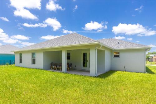 a white house with a green lawn at Coosa Dr in Port Saint Lucie