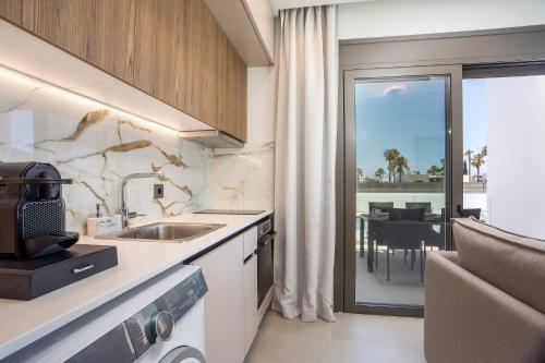 a kitchen with a sink and a view of a table at Nostos Luxury Apartments in Kremasti