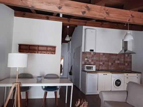 eine Küche und ein Wohnzimmer mit weißen Schränken und einem Tisch in der Unterkunft El ático de Esther in Haro