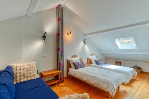 a attic room with two beds and a couch at Lumières du Lac in Lugrin