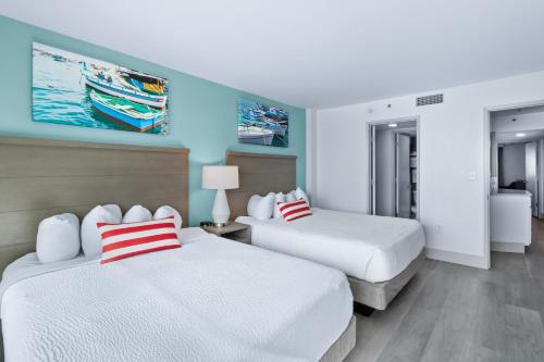 two beds in a room with blue and white at Compass Cove in Myrtle Beach