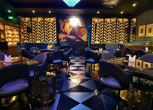 a restaurant with blue chairs and tables in a room at Radisson Hotel Muscat Panorama in Muscat