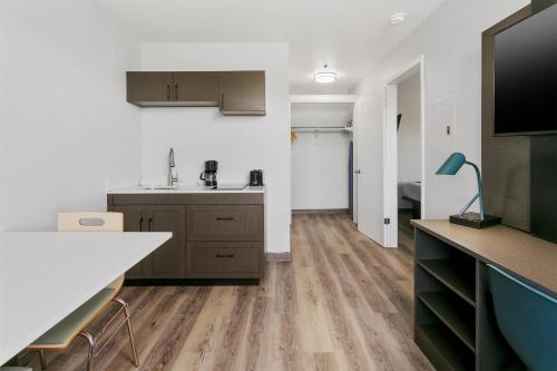 an apartment kitchen with a sink and a tv at Studio 6 Tempe, AZ Elliot Road in Tempe