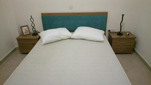 a bedroom with a large bed with two pillows at villa by the sea in Káto Alepokhórion