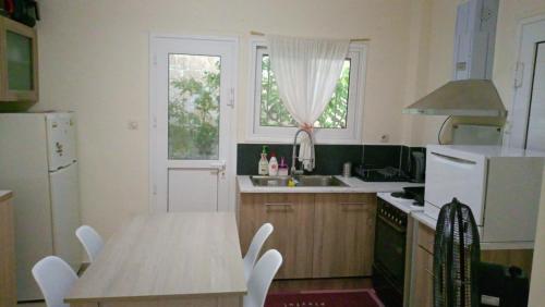 a kitchen with a table and a white refrigerator at villa by the sea in Káto Alepokhórion