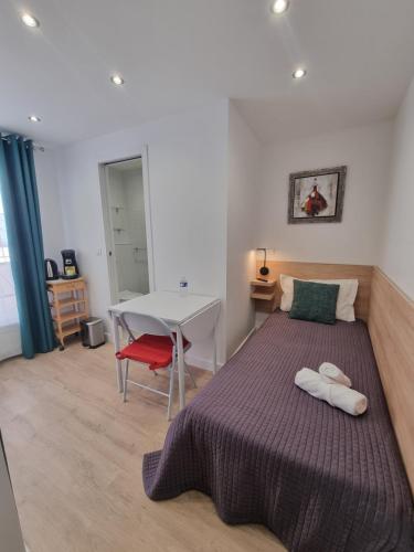 a bedroom with a bed and a table and a table at Hotel De L'Horloge in Paris
