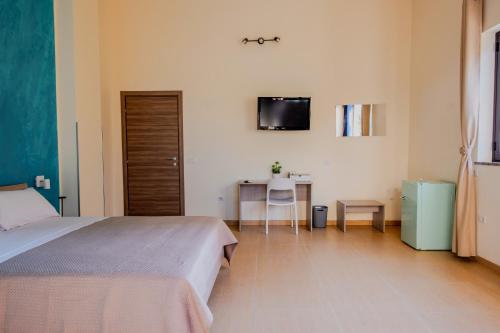 a bedroom with a bed and a desk and a tv at B&B Etesia in Vibo Valentia