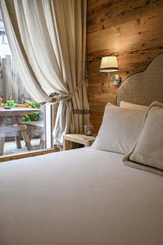 a bedroom with a bed and a window with a table at Al Baitin - Charme & Nature - in Santa Caterina Valfurva