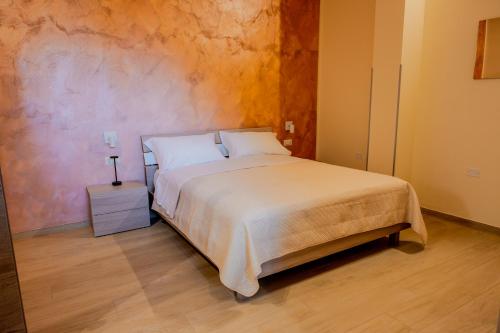 a bedroom with a white bed with a night stand at B&B Etesia in Vibo Valentia
