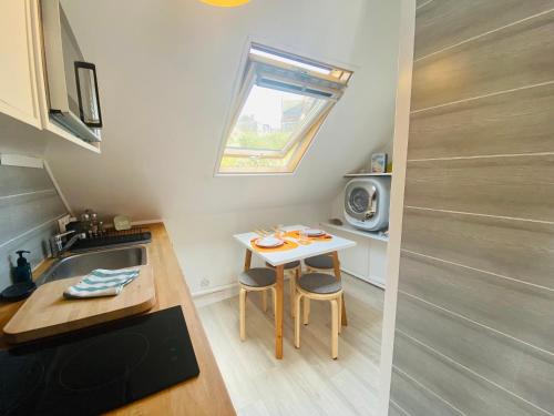 une petite cuisine avec une petite table et un évier dans l'établissement Chez Zivou au pied de la plage, à Mers-les-Bains