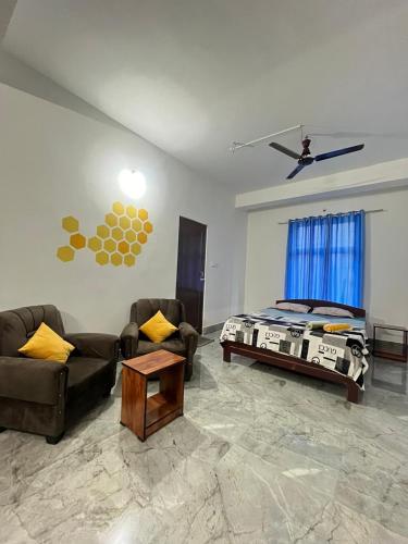 a living room with a bed and a couch and a table at ABDB Homestay in Guwahati