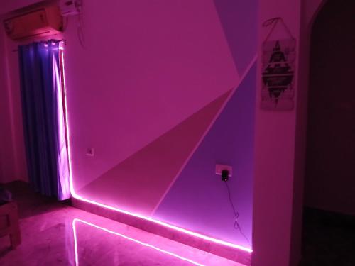 a room with a pink lighted room with a wall at ABDB Homestay in Guwahati