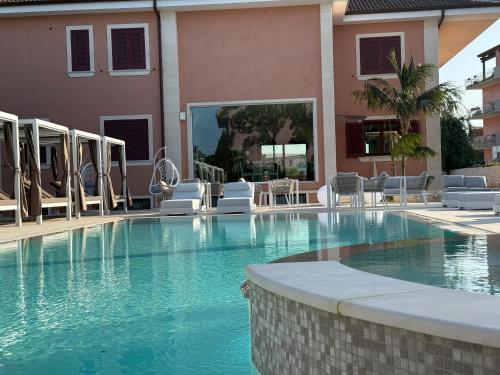a large swimming pool with chairs and a building at Villa Giulia in Siracusa
