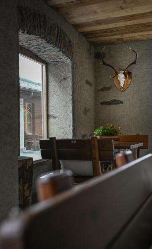 a dining room with a table and chairs and a window at Al Baitin - Charme & Nature - in Santa Caterina Valfurva