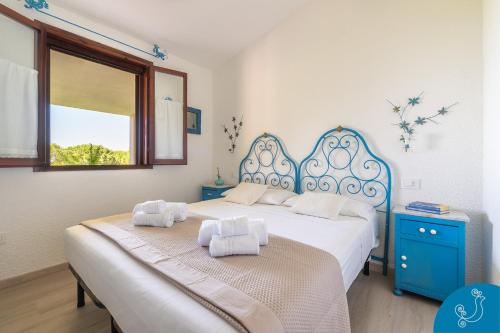 two beds in a bedroom with blue and white at La Bouganville - House with garden and sea view in Geremèas
