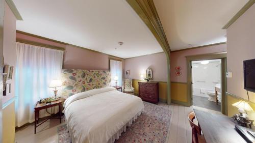 a bedroom with a bed and a desk and a television at The Red Lion Inn in Stockbridge
