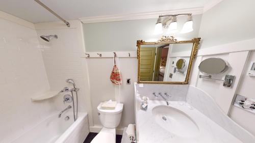a bathroom with a tub and a toilet and a mirror at The Red Lion Inn in Stockbridge