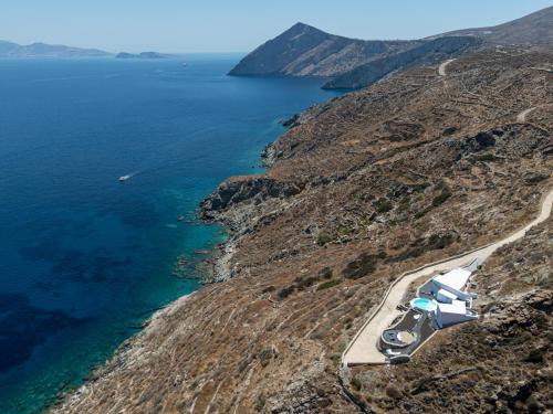 an airplane is parked on a hill next to the ocean at CALDERA CASABLANCA in Ano Meria