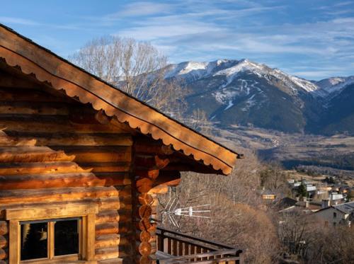 a log cabin with snowy mountains in the background at Chalet Inuit in Font Romeu Odeillo Via