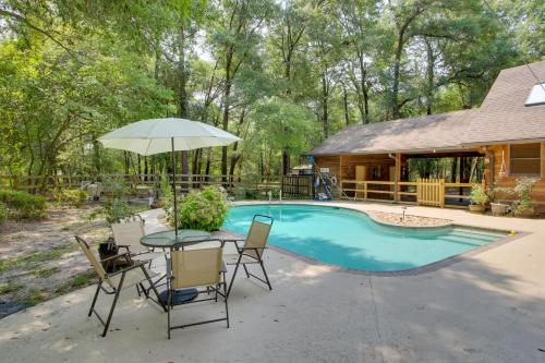 a patio with a table and an umbrella next to a pool at Golf and Hike Nature Escape with Sauna in Hephzibah in Hephzibah