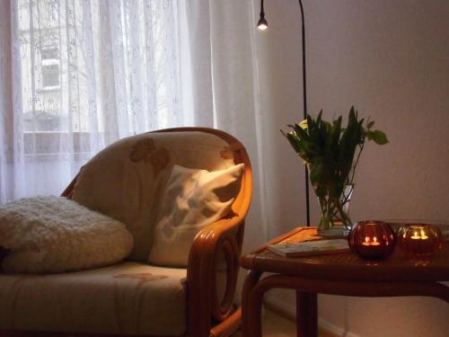 a chair and a table in a room with a window at SchlossparkFerienwohnungen Rheinsberg mit Garten in Rheinsberg