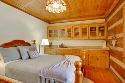 a bedroom with a bed and wooden cabinets and a chandelier at Golf and Hike Nature Escape with Sauna in Hephzibah in Hephzibah