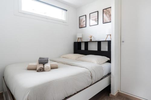a white bedroom with a large bed with white sheets at Barrière naturelle in Toulouse