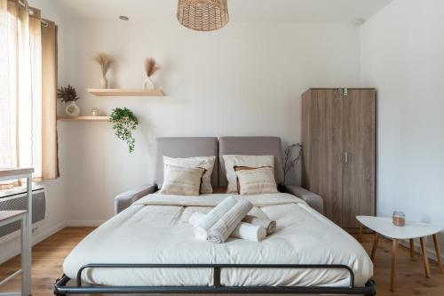 a bedroom with a large bed with towels on it at Barrière naturelle in Toulouse