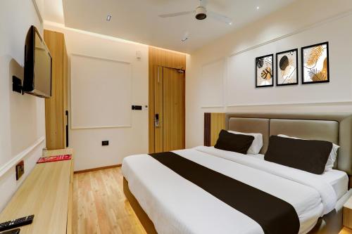 a bedroom with a large bed and a flat screen tv at Hotel O Nirmal Restaurant Bar Banquet & Rooms Faridapur in Alambagh