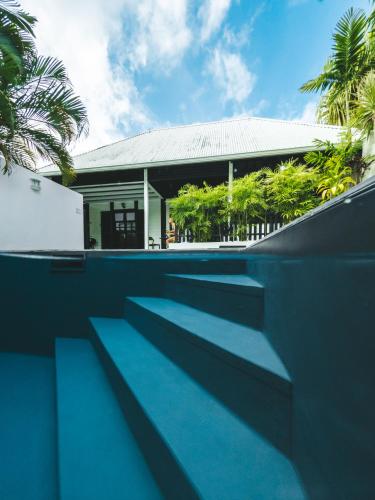 a house with blue steps in front of a building at Domaine de la Palmeraie - Villas Lodge in Le Diamant