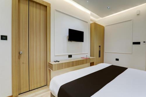 a bedroom with a bed and a tv on a wall at Hotel O Nirmal Restaurant Bar Banquet & Rooms Faridapur in Alambagh