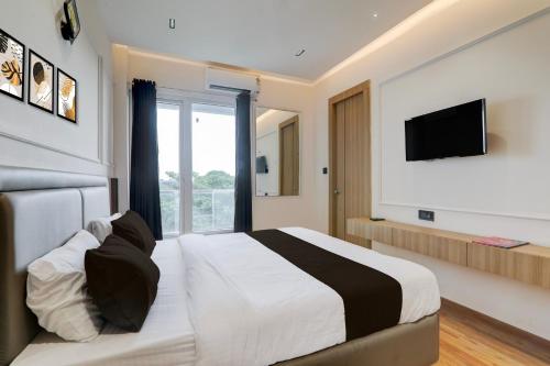 a hotel room with a bed and a television at Hotel O Nirmal Restaurant Bar Banquet & Rooms Faridapur in Alambagh