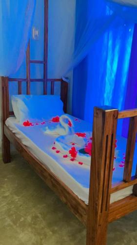 a bed in a blue room with flowers on it at Zenji poa villas in Jambiani