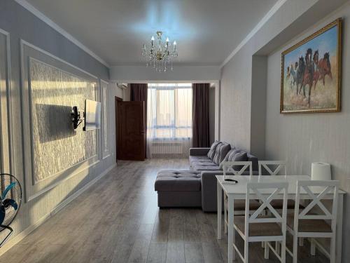 una sala de estar con un sofá y una mesa en apartment with view of Ala-Too, en Bishkek