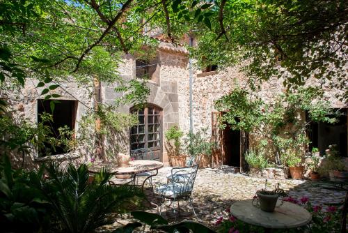 un jardín con mesa y sillas frente a un edificio en Finca Son Ru, en Deià