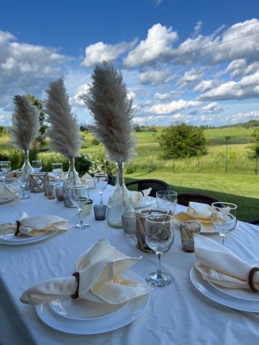 a table with white plates and wine glasses on it at Vila Trakai in Trakai
