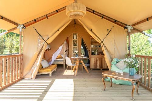 a tent with a table and chairs in it at Etna Glamping in Milo