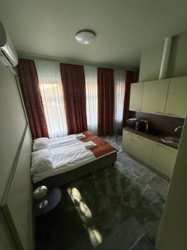 a small room with a bed and a kitchen at Moja Accommodation in Kaunas