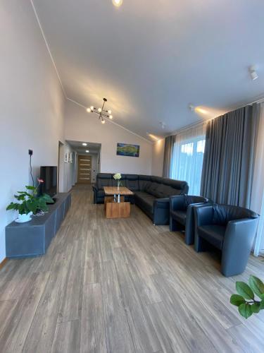 a large living room with couches and a tv at Family house in Valmiera
