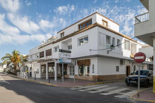 a white building on the corner of a street at Apartamentos Almadraba in Zahara de los Atunes
