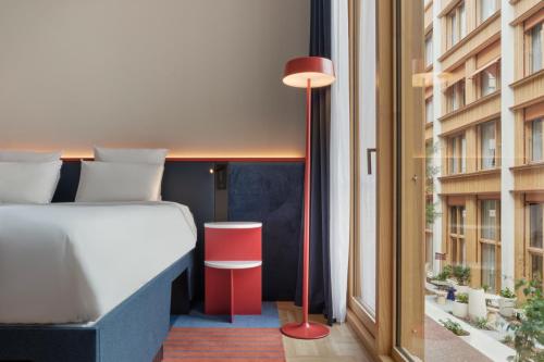 a bedroom with a bed and a red floor lamp at TRIBE Paris Pantin in Pantin