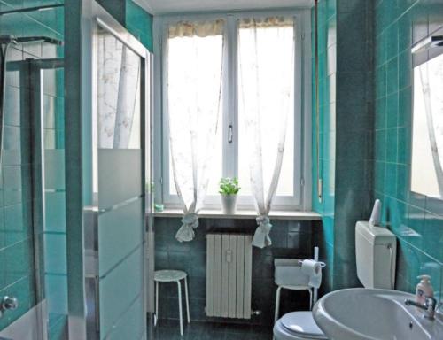 a bathroom with a toilet and a sink and windows at ROSSO MAGENTA - Luminoso loft in centro e a due passi dalla stazione in Turin