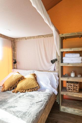 a bed with two pillows on it in a bedroom at Etna Glamping in Milo