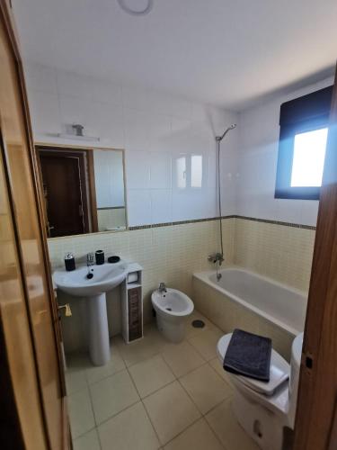 Un baño con lavabo, bañera e inodoro. en Villa Sol Naciente, en Lajares