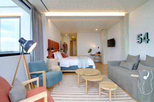 ein Wohnzimmer mit einem Sofa und einem Bett in der Unterkunft Coco-Mat Hotel Athens in Athen