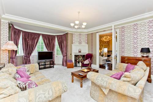 a living room with two couches and a tv at Luxury-3-bedroom Ramsay Garden Apartment next to Edinburgh Castle in Edinburgh
