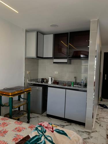 a kitchen with white cabinets and a table at Studio in Porto Said Compound in Port Said