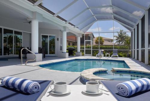a swimming pool with a patio and an outdoor swimming poolvisor at Cape Serenity- Premier Waterfront Villa with Kayaks and Bikes in Cape Coral