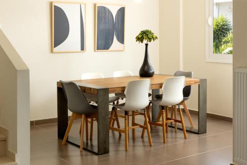 a dining room with a wooden table and chairs at Amare Luxury Living in Volos